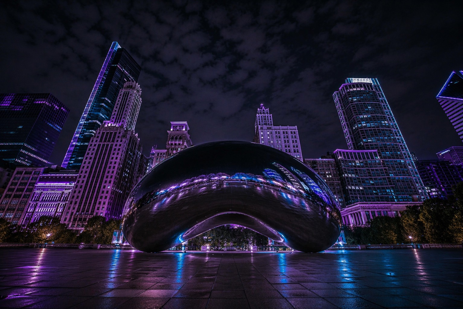 Cloud Gate in Chicago at night, beneath the city skyline